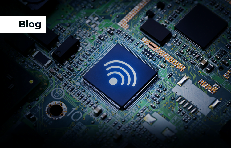 Close-up of a circuit board with a central chip displaying a WiFi symbol, surrounded by other electronic components.